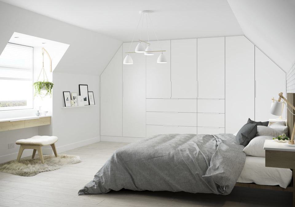 Fitted white bedroom wardrobes in a loft room